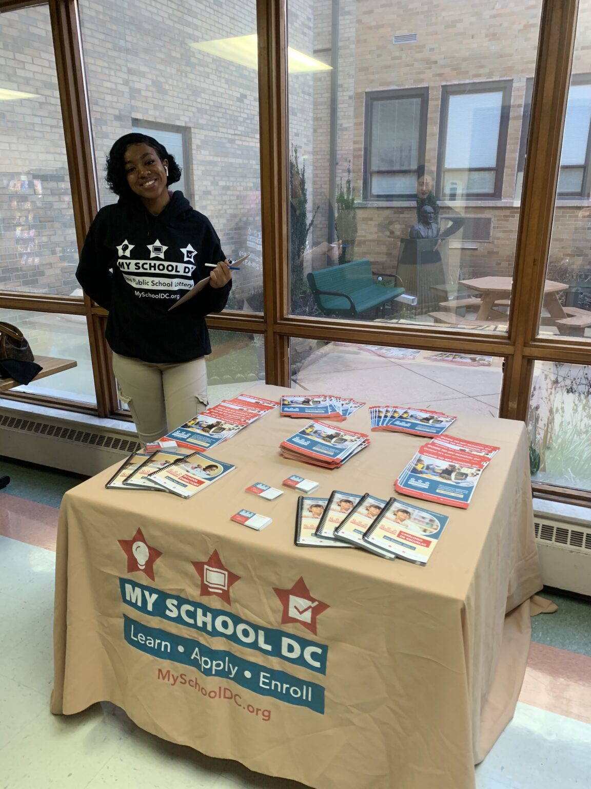 A woman standing next to a table with books on it.