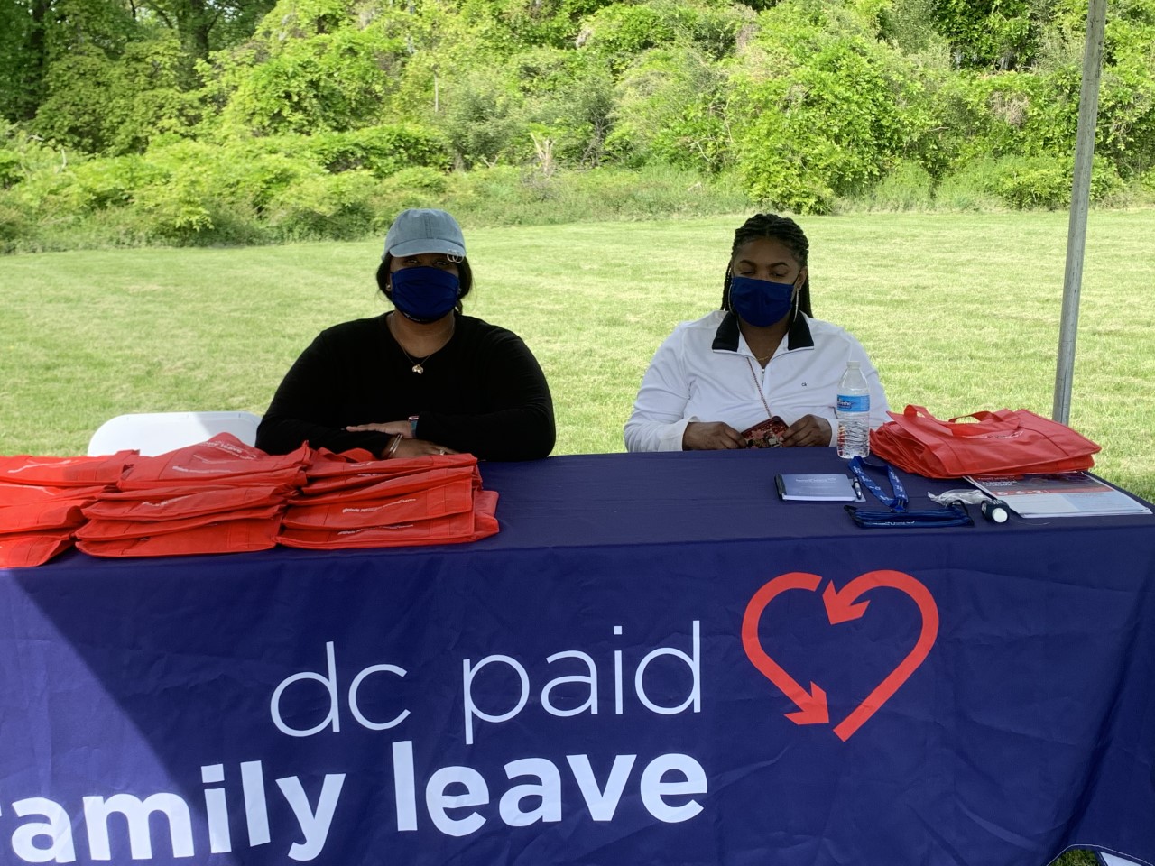 Two people sitting at a table with a sign that says dc paid family leave.